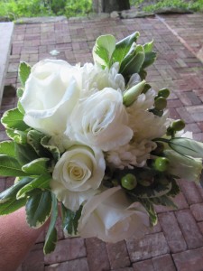 The bridal bouquet contained roses, cremones, lisianthus, hypernicum berries, and variegated pittosporum.