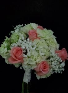 Bridesmaids carried coral roses with hydrangeas and baby's breath.